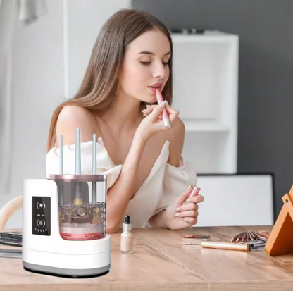 Woman applying lipstick in front of a Electric Makeup Brush Cleaner on a table.